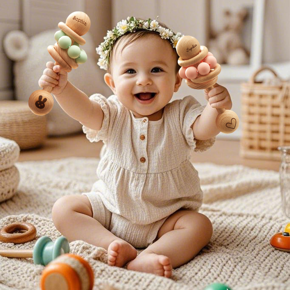 Baby sitting on a rug with wooden toys, wearing a floral headband.