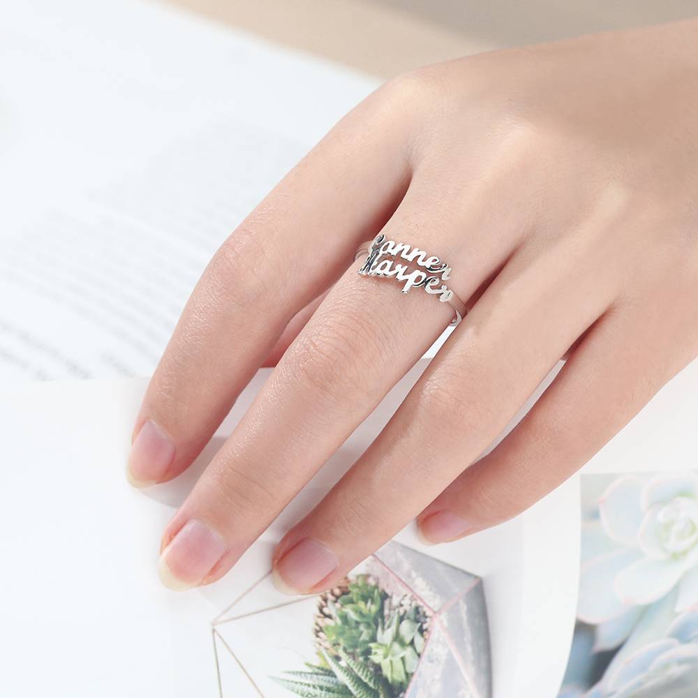 Silver ring with 'Anne Kopf' engraving on a hand against a light background