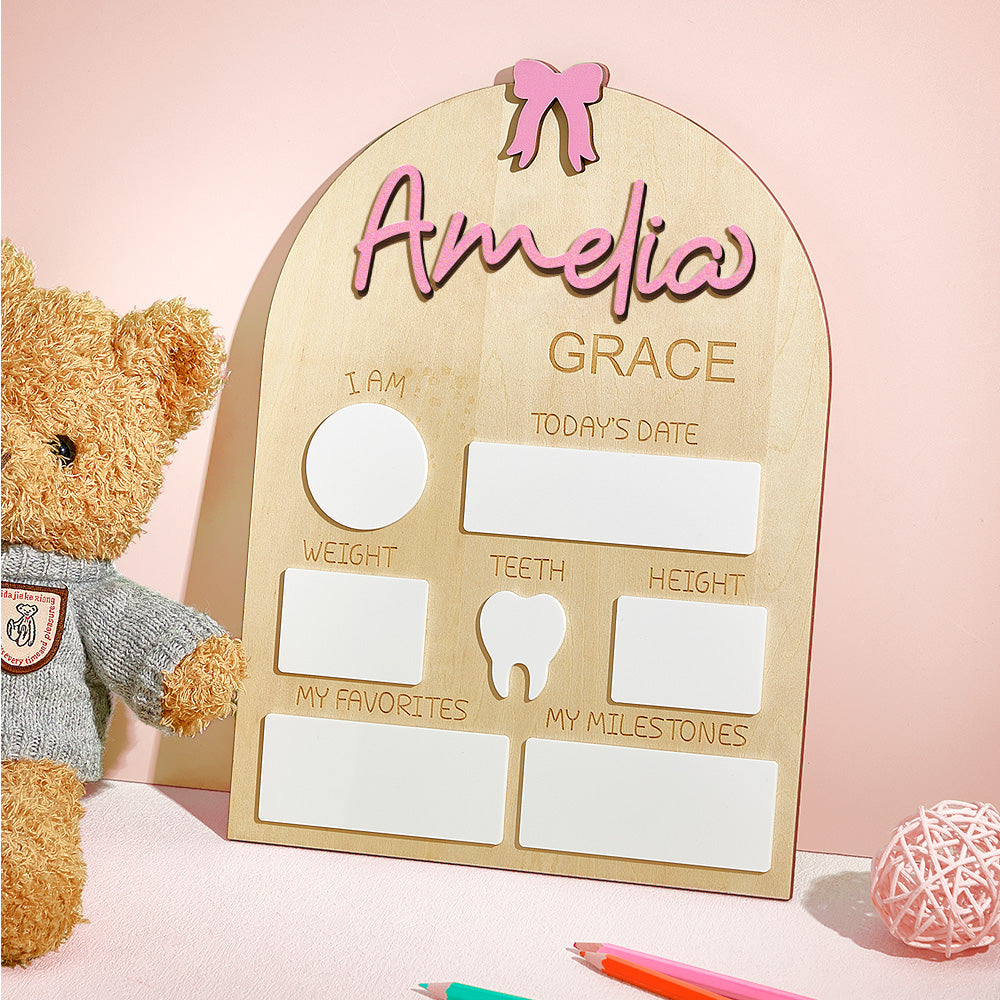 Baby milestone board with 'Amelia Grace' and a teddy bear on a pink background