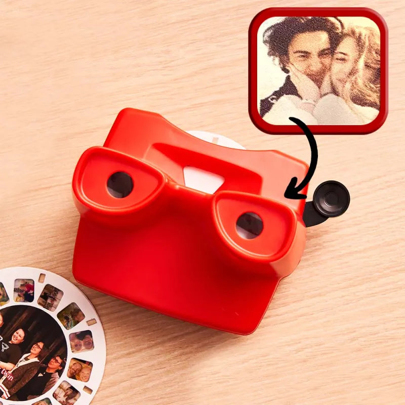 Red instant camera on a wooden surface with a photo of a couple and a reel of film.