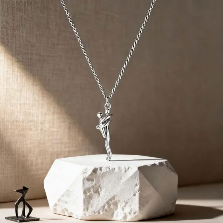Silver necklace with a pendant of a figure on a textured surface